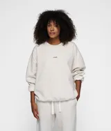 Buzo oversize color gris claro jaspeado, confeccionado en felpa gruesa cepillada. Presenta un parche del logo de 10DAYS en el pecho, un bordado de minirayas en la espalda, cuello redondo de canalé y ribetes de canalé en puños y bajo.