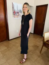 Vestido midi negro de algodón, con mangas cortas, cuello redondo y bolsillos laterales.