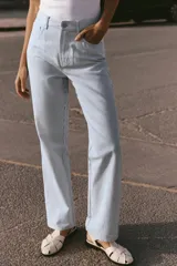 Pantalón de tiro alto con cinco bolsillos, estampado a rayas verticales celestes y blancas, de pierna recta y tejido con hilo metalizado.