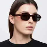 Lentes de sol Dotia de diseño cuadrado con bordes redondeados, montura carey y lentes polarizadas color verde oscuro.