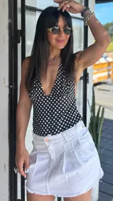 Top negro con lunares blancos, escote halter y espalda descubierta.