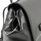 Mochila negra de símil cuero con solapa y botones imantados. Tiene un bolsillo interno con cierre y dos abiertos, herrajes plateados, correa regulable y forro de algodón y poliéster.