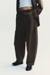 Pantalón cargo negro de corte amplio con cintura ajustable con cordón, bolsillos laterales y bolsillos tipo parche en las piernas.