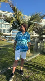 Camisa celeste con estampado geométrico en tonos azules y blancos, de manga corta y corte recto.