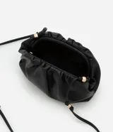 Cartera transversal pequeña color beige, confeccionada en material sintético con bretel fino de cordón con detalles de metal.