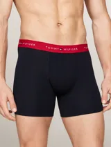 Pack de tres calzoncillos bóxer Tommy Hilfiger de algodón elástico color azul marino, con cinturas elásticas en blanco, rojo y negro con el logo de la marca.