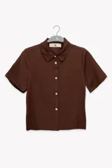 Camisa marrón de manga corta con cuello clásico y cierre frontal con botones blancos.