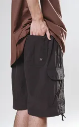 Bermuda cargo negra de nylon y spandex, con calce relax-fit, cintura elástica, cordón de ajuste y bolsillos delanteros con fuelle.