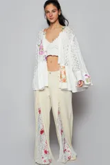 Pantalón de corte flare color crema, con paneles estampados florales y detalles de patchwork a los laterales.