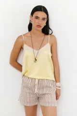 Short de tela color blanco con rayas verticales negras, cintura elastizada con cordón ajustable.