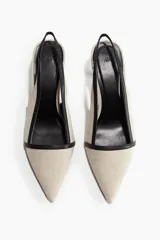 Zapato destalonado color beige con puntera fina y ribete negro. El taco es fino y mide 7 cm.