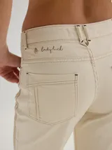 Pantalón negro de gabardina con alforzas verticales en los laterales y aberturas en el ruedo.