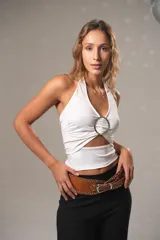 Musculosa blanca con escote halter, corte en el abdomen y aro metálico en el centro del pecho.