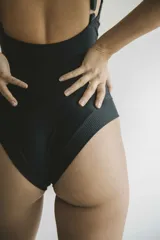 Malla entera negra con escote en V, breteles finos y espalda baja.
