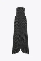 Vestido midi negro con estampado de lunares blancos, cuello halter con pañuelo integrado, sin mangas y bajo asimétrico.