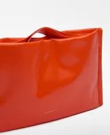 Bolso de mano rectangular color naranja brillante, con asa de mano y asa larga regulable extraíble. Tiene un compartimento con cierre magnético y logo grabado.