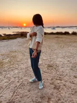 Sweater tejido en boucle color crema, de corte holgado y mangas largas.