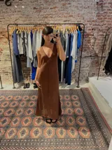 Vestido largo tejido color marrón, con escote en V, sisa profunda y calado en la parte inferior.