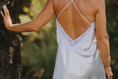 Camisón azul de satén con breteles finos y escote en V con puntilla blanca.