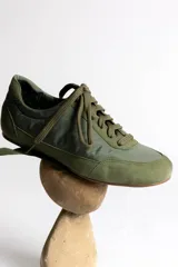 Zapatillas deportivas verde oliva con cordones y suela marrón.