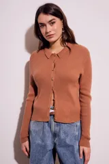 Cardigan negro de punto con cuello polo, manga larga y cierre frontal con botones.