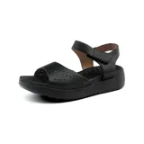 Sandalias bajas color beige con plataforma, tira ancha sobre el empeine con calados y tira con velcro en el tobillo.