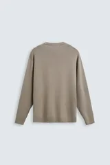 Jersey color topo de corte amplio, tejido en hilatura con mezcla de viscosa. Tiene cuello redondo, manga larga y terminaciones en rib.