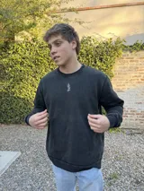 Buzo negro de algodón con efecto lavado y pequeño logo bordado en el pecho.