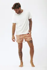 Short de baño color salmón con estampado de tablas de surf en blanco y celeste.