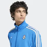 Campera Adidas del Real Madrid, modelo Terrace Icons, color celeste con detalles en blanco. Presenta cierre frontal, cuello alto, bolsillos frontales y escudo bordado del Real Madrid.