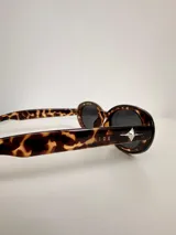 Lentes de sol con marco ovalado de carey y cristales oscuros, con protección UV400.