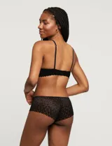 Conjunto de lencería Réne Rofé, compuesto por un soutien de encaje negro con microtul y un panty brasilero de encaje negro con microtul.