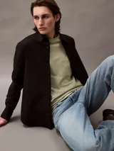 Remera color verde oliva de corte holgado, con cuello redondo, mangas cortas y bolsillo en el pecho con logo bordado.