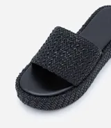 Sandalia flatform negra con superficie trenzada, tira ancha y puntera redonda.