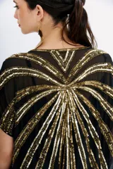 Vestido largo tipo kaftan color negro, con escote en V y mangas cortas. Confeccionado en georgette con bordados de lentejuelas doradas. Incluye viso con escote en V, puntilla y breteles regulables.