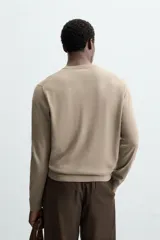 Jersey de hombre color beige claro, tejido en lana, de corte recto, cuello redondo y mangas largas con terminaciones en rib.