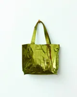 Bolso tipo tote de cuero color verde metalizado con doble asa de hombro y cierre con lazos de cuero marrón.