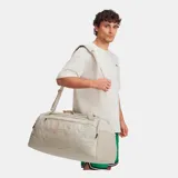 Bolso deportivo Under Armour Undeniable 5.0 mediano, color beige con logo de la marca en el frente. Cuenta con doble asa de mano, correa de hombro ajustable y múltiples bolsillos con cierre.