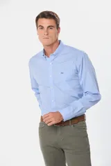 Camisa celeste a cuadros con cuello abotonado, manga larga, bolsillo en el pecho y logo bordado.
