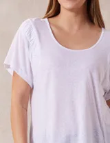 Remera amarilla de lino y poliéster, manga corta con fruncido en los hombros y escote redondo.