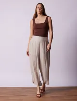 Pantalón palazzo color beige de gasa bambula, marca Nanette, con pretina ancha y elástico en la parte trasera. Tiene pierna ancha, largo al tobillo y short interno.