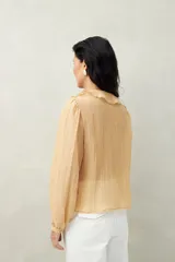 Camisa negra de tencel liviana con volados románticos y manga corta.