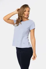 Remera color beige con estampado de aves en tonos celeste, lila y dorado.