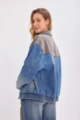 Campera bomber de mezclilla en tonos gris y azul, con cierre frontal y diseño oversize.