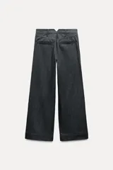 Pantalón de jean azul oscuro, de tiro medio, corte wide leg y bolsillos laterales.