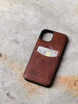 Funda de cuero marrón para iPhone con tarjetero en la parte posterior y logo de la marca Sierra Mora grabado en la parte inferior.