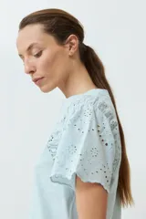 Remera color verde agua con mangas cortas de broderie.