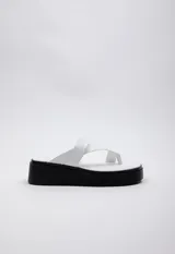 Sandalia de símil cuero con doble tira entrelazada y plataforma de 4.5 cm.