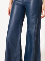 Pantalón largo de cuero ovino distress color azul marino, de pata ancha con recortes diagonales y curvos en delantero y espalda, bolsillos delanteros y bolsillos plaqué en la parte trasera.