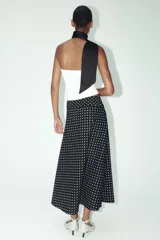 Falda midi negra con estampado de lunares blancos, de tiro alto y corte evasé.